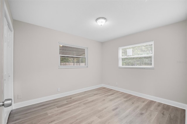 empty room featuring light wood-type flooring and a healthy amount of sunlight