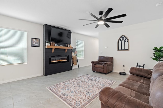 living room featuring a fireplace, ceiling fan, plenty of natural light, and light tile patterned floors