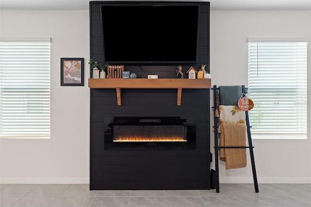 interior details with tile patterned flooring and a large fireplace