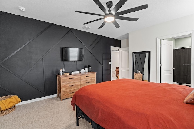 bedroom featuring a textured ceiling, light carpet, and ceiling fan