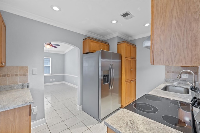 kitchen featuring stainless steel fridge, sink, crown molding, and tasteful backsplash