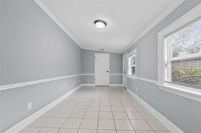 tiled empty room featuring ornamental molding and vaulted ceiling