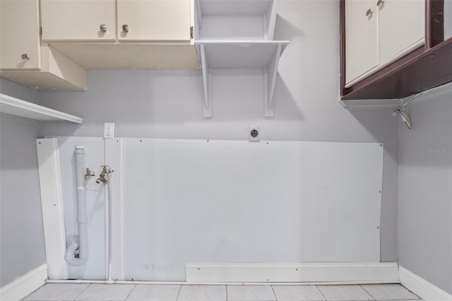 laundry area featuring light tile patterned floors, cabinets, hookup for a washing machine, and hookup for an electric dryer