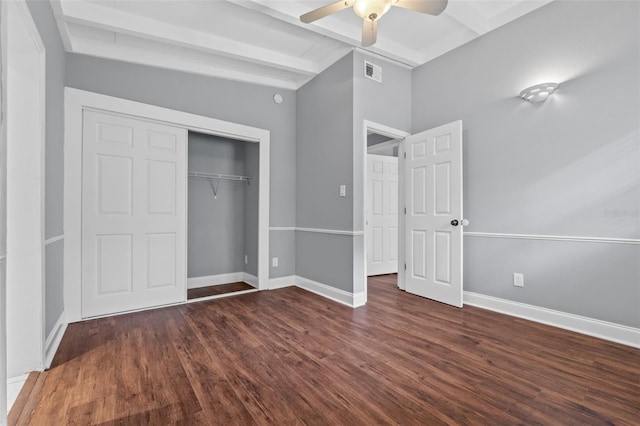 unfurnished bedroom featuring beamed ceiling, ceiling fan, a closet, and dark hardwood / wood-style flooring