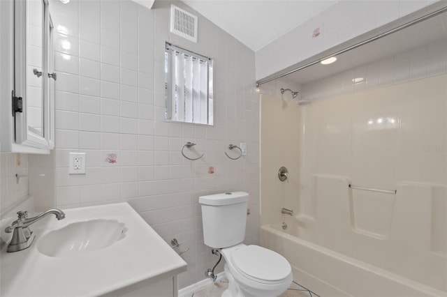 full bathroom featuring toilet, washtub / shower combination, tile walls, and a textured ceiling