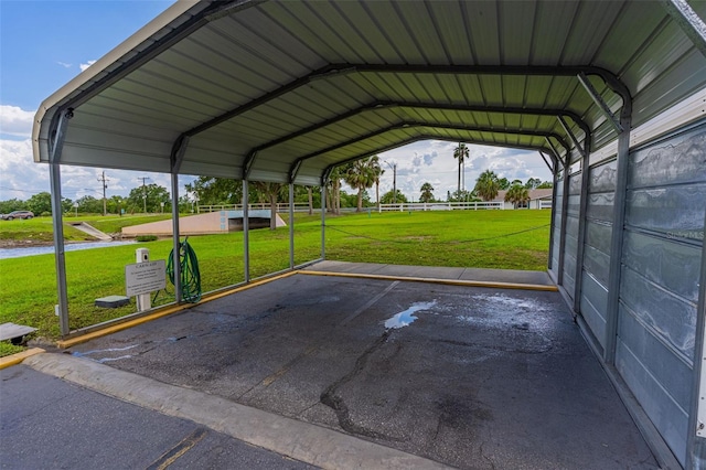 view of parking / parking lot featuring a lawn and a carport