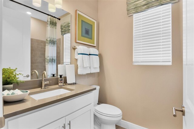 bathroom with toilet, vanity, and curtained shower