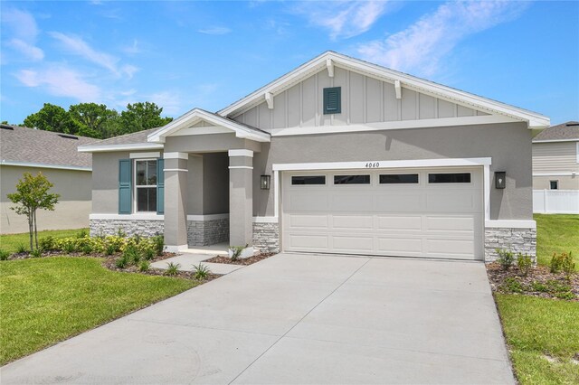 4060 Bannock Ave, Tavares, FL 32778 - craftsman inspired home with stone siding, concrete driveway, a front lawn, and a garage