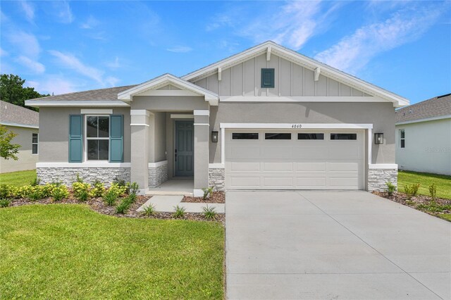 4060 Bannock Ave, Tavares, FL 32778 - craftsman house featuring stone siding, a front yard, a garage, and concrete driveway