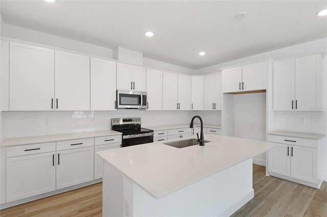 4060 Bannock Ave, Tavares, FL 32778 - kitchen featuring stainless steel appliances, a sink, light wood-style floors, decorative backsplash, and recessed lighting