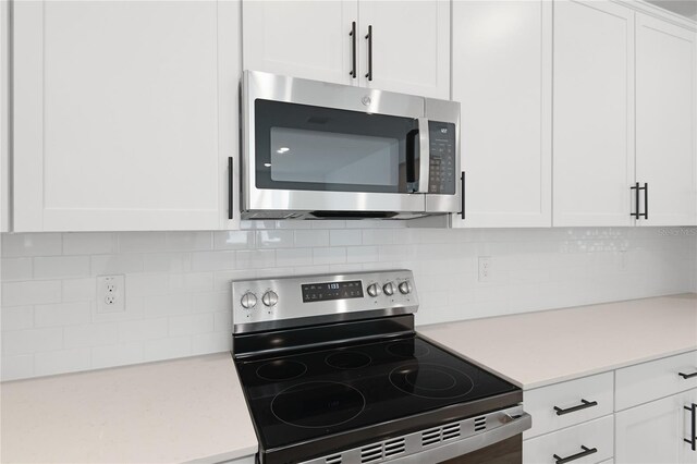 4060 Bannock Ave, Tavares, FL 32778 - kitchen with stainless steel appliances, light countertops, white cabinetry, and tasteful backsplash