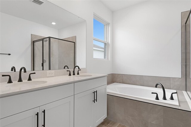 4060 Bannock Ave, Tavares, FL 32778 - bathroom featuring a stall shower, a bath, double vanity, and wood finished floors