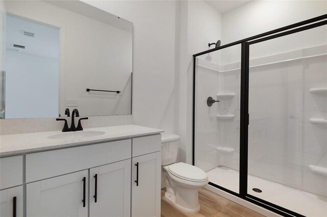 4060 Bannock Ave, Tavares, FL 32778 - full bathroom featuring toilet, a shower stall, vanity, and wood finished floors