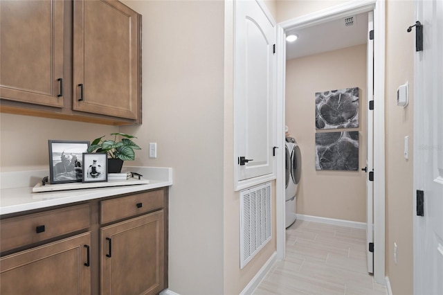 washroom featuring baseboards and separate washer and dryer
