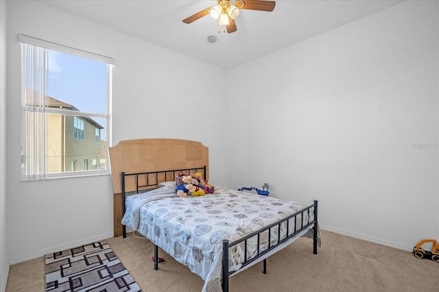 carpeted bedroom with multiple windows and ceiling fan