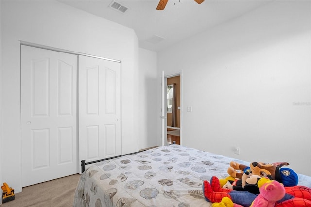 carpeted bedroom featuring ceiling fan and a closet