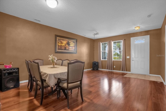 dining space featuring a textured ceiling and hardwood / wood-style flooring