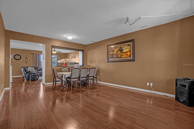 dining area featuring a textured ceiling, hardwood / wood-style flooring, and ceiling fan