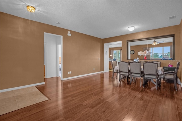 dining room with a textured ceiling, hardwood / wood-style flooring, and ceiling fan