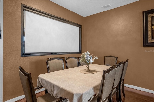4523 Ashtubula Ct, Orlando, FL 32818 - dining room with wood finished floors, baseboards, and a textured wall