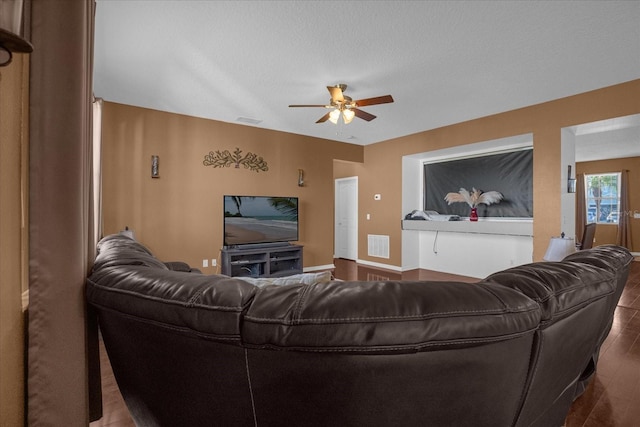 living room with hardwood / wood-style floors, ceiling fan, and a textured ceiling