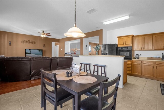 dining space with light hardwood / wood-style floors and ceiling fan