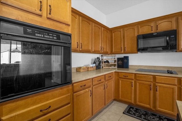 kitchen with black appliances and light tile patterned flooring