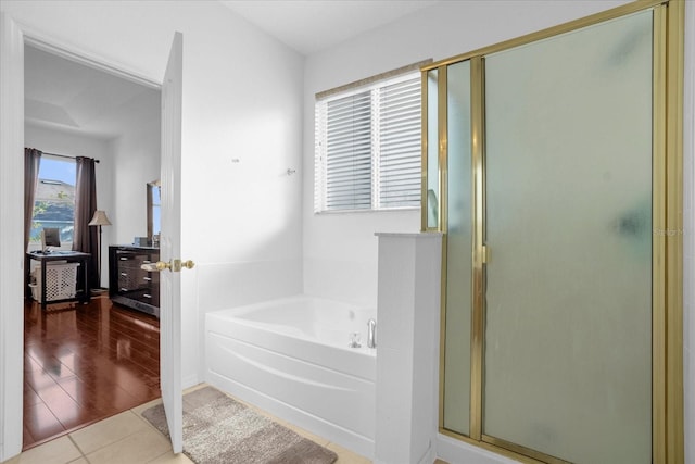 bathroom featuring hardwood / wood-style flooring and plus walk in shower