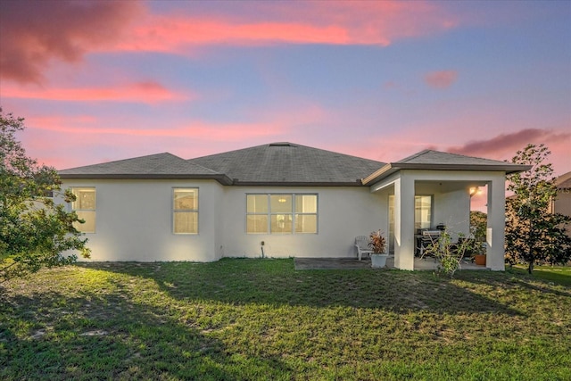 4523 Ashtubula Ct, Orlando, FL 32818 - rear view of house featuring stucco siding, a patio, a yard, and a shingled roof