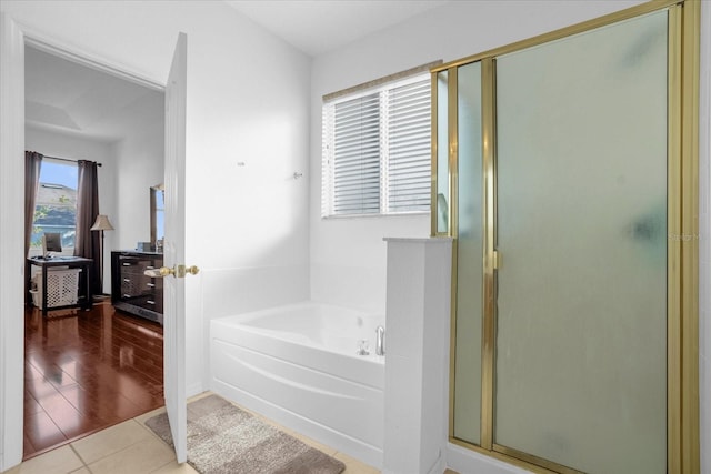 4523 Ashtubula Ct, Orlando, FL 32818 - bathroom featuring a garden tub, a shower stall, and tile patterned floors