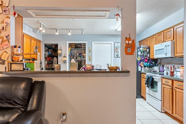 kitchen with kitchen peninsula, a kitchen breakfast bar, white appliances, a textured ceiling, and light tile patterned floors