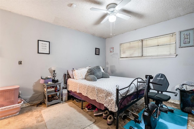 bedroom with ceiling fan and a textured ceiling