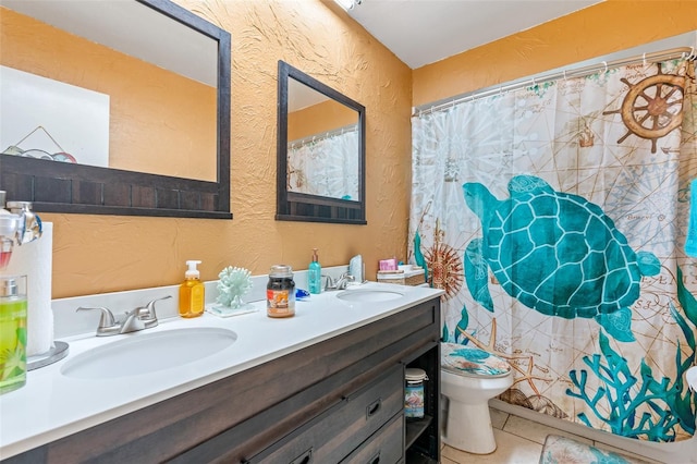 bathroom with tile patterned flooring, vanity, and toilet