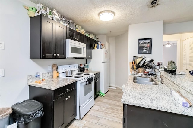 976 Leeward Pl Unit 102, Altamonte Springs, FL 32714 - kitchen with white appliances, a sink, dark cabinets, and a textured ceiling