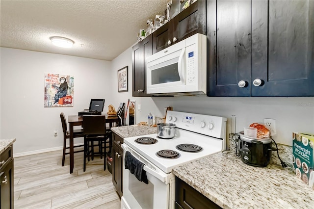 kitchen featuring white appliances, light hardwood / wood-style flooring, light stone countertops, a textured ceiling, and dark brown cabinetry