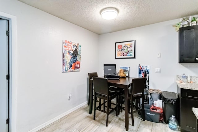 dining room featuring a textured ceiling and light hardwood / wood-style flooring