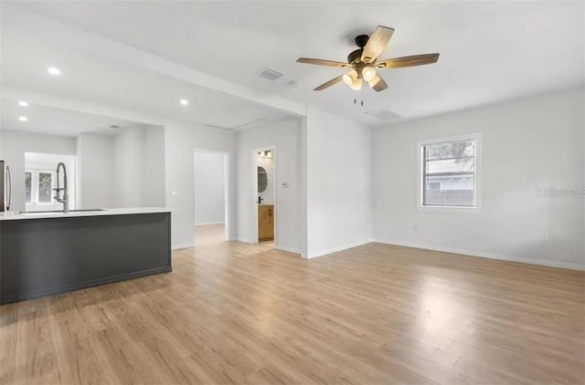 unfurnished living room featuring ceiling fan and light hardwood / wood-style floors