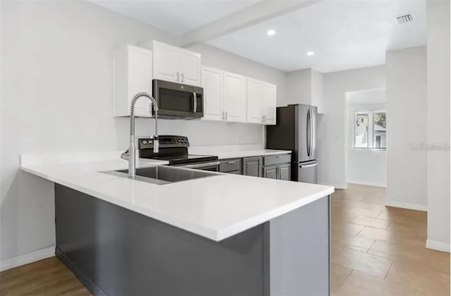 kitchen featuring white cabinetry, kitchen peninsula, stainless steel appliances, and a breakfast bar