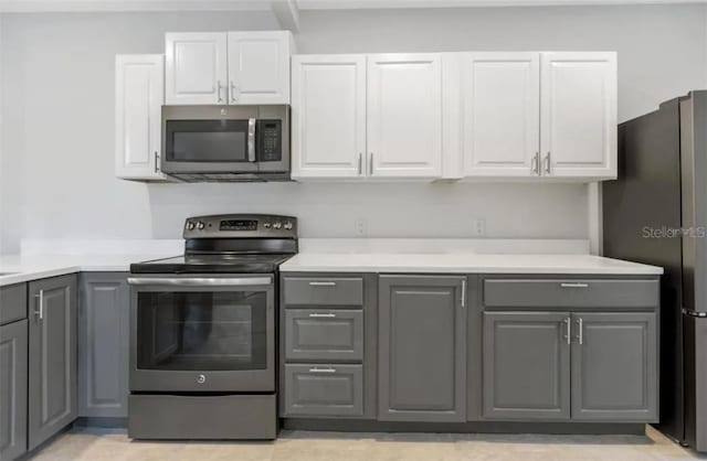 kitchen featuring stainless steel appliances, gray cabinets, and white cabinetry