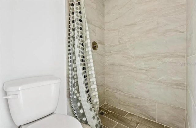 bathroom featuring toilet and a shower with shower curtain