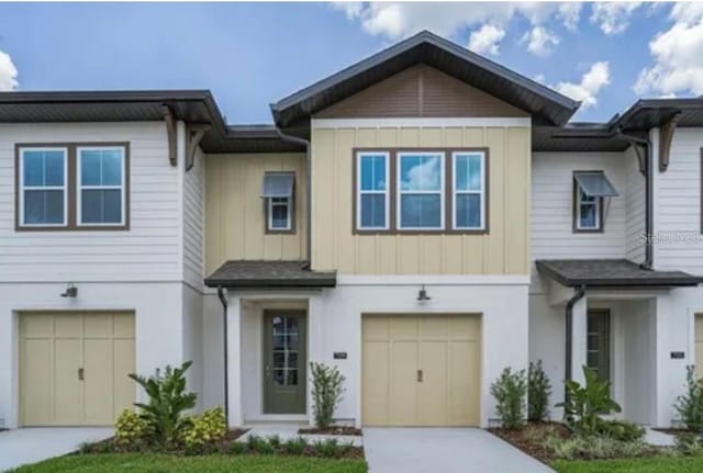 709 Benoi Dr, Davenport, FL 33896 - townhome / multi-family property with an attached garage, concrete driveway, and board and batten siding