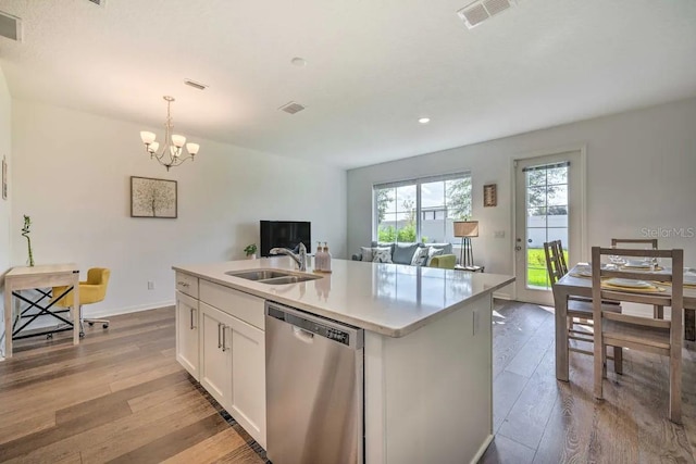 709 Benoi Dr, Davenport, FL 33896 - kitchen with stainless steel dishwasher, a sink, light wood-style floors, a chandelier, and white cabinets