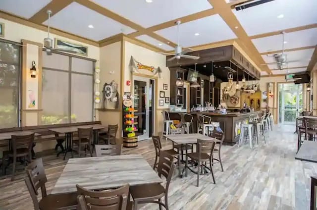 dining space featuring beamed ceiling, ceiling fan, light hardwood / wood-style flooring, and coffered ceiling