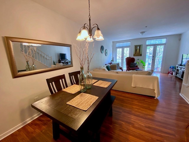 dining area with french doors, dark wood-type flooring, and a notable chandelier