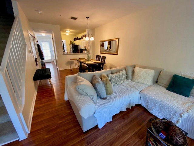 living room featuring dark wood-type flooring and a notable chandelier