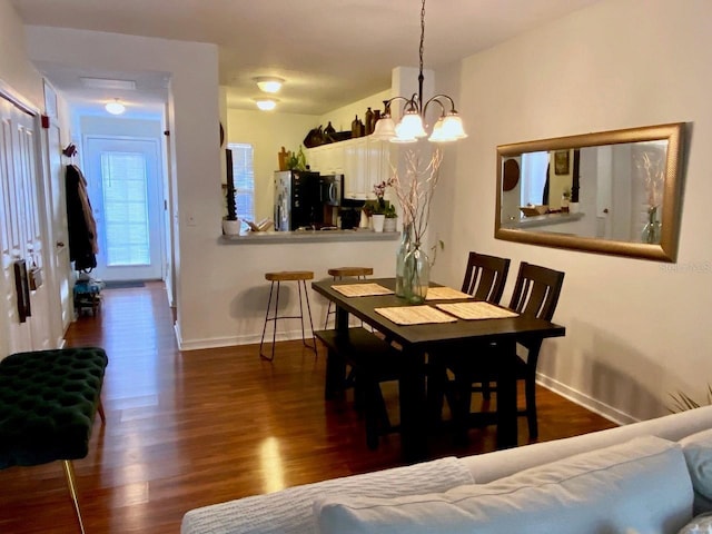 dining room featuring dark wood-type flooring and a notable chandelier