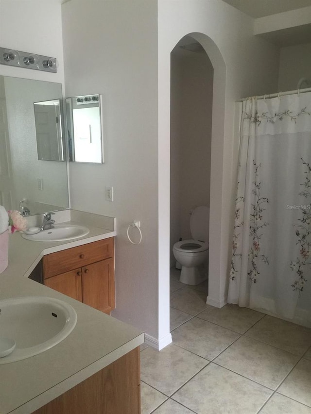 bathroom with tile patterned flooring, vanity, toilet, and a shower with shower curtain