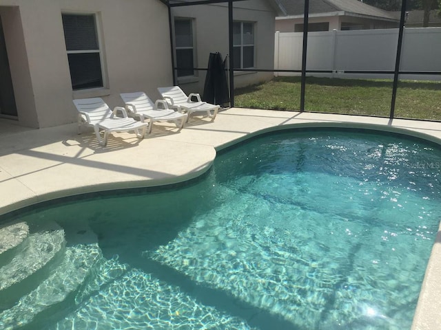 view of swimming pool with a patio and glass enclosure