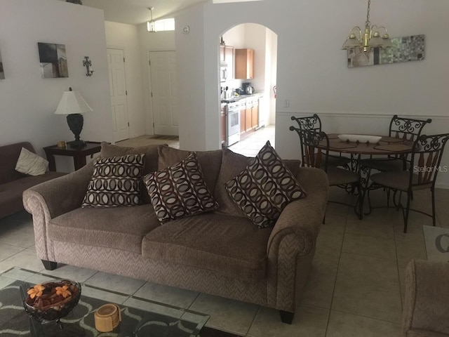 tiled living room with a chandelier and vaulted ceiling