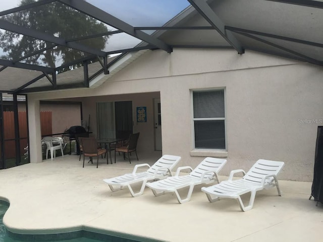 back of property featuring a patio and glass enclosure